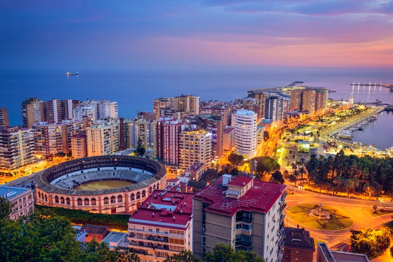 an aerial view of the malaga cityscape during sunset