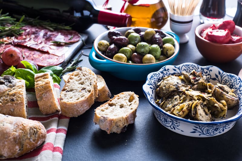 party food selection of tapas ingredients and bread on a table