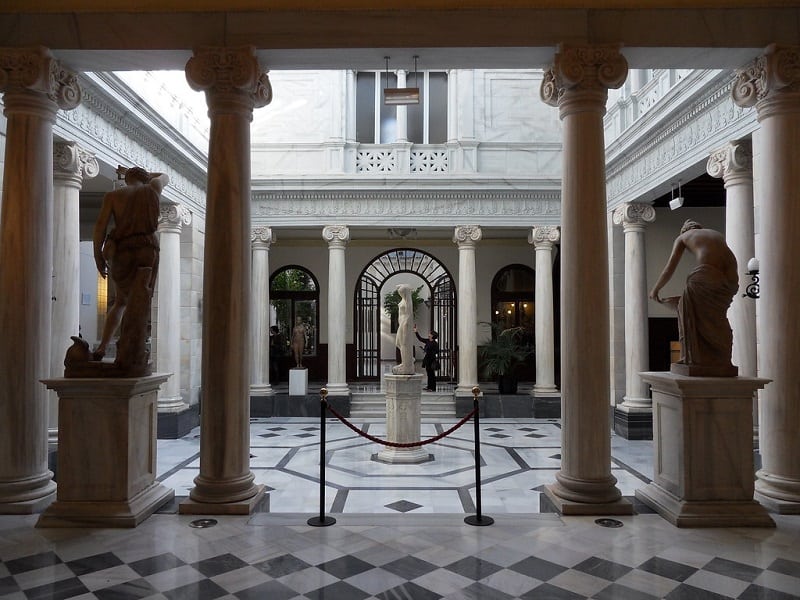 inside view of Real Casino de Murcia with a statue in the middle, and other statues in the corner and columns