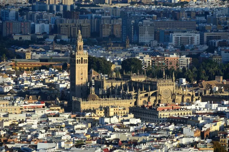 an aerial view of the city of Seville with a gothic Cathedral in the middle