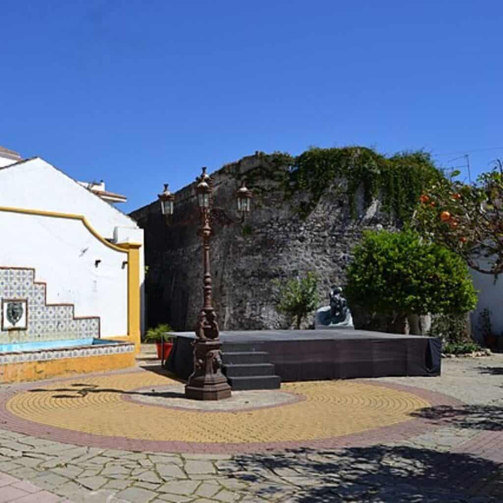 a courtyard with a fountain in front of an old building