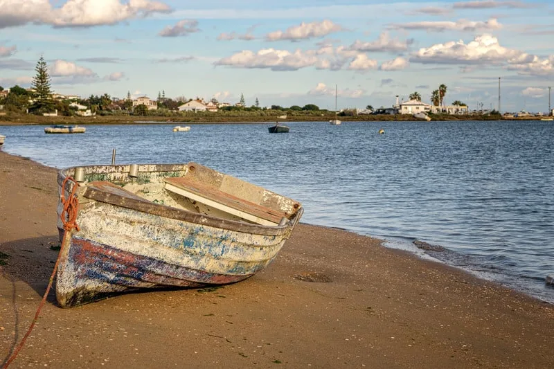 VIew of old wooden boat ashore in the beach of El Rompido, Huelva, Spain.