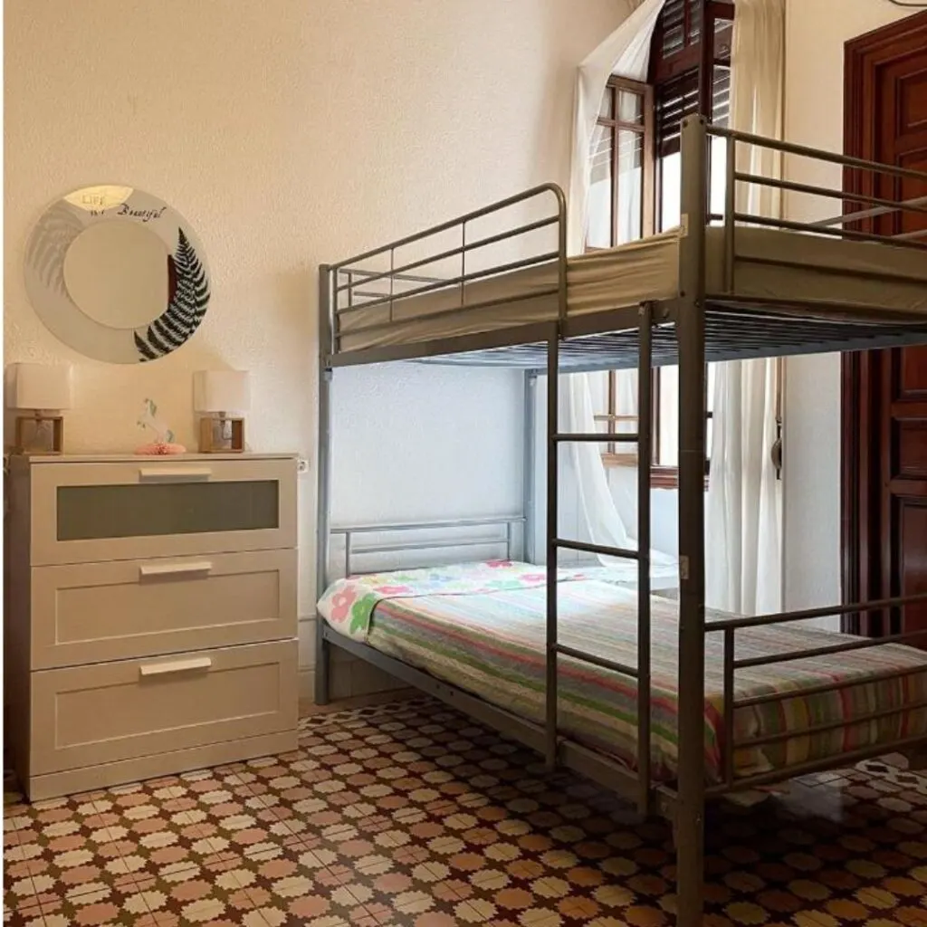 a bunk bed in a small room with a tiled floor
