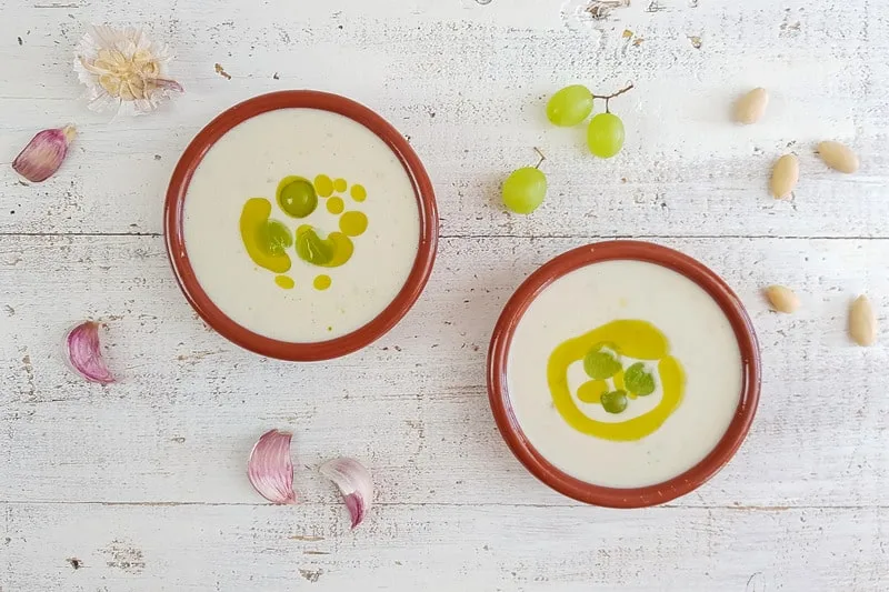 cold pear soup in 2 bowls decorated with olive oil