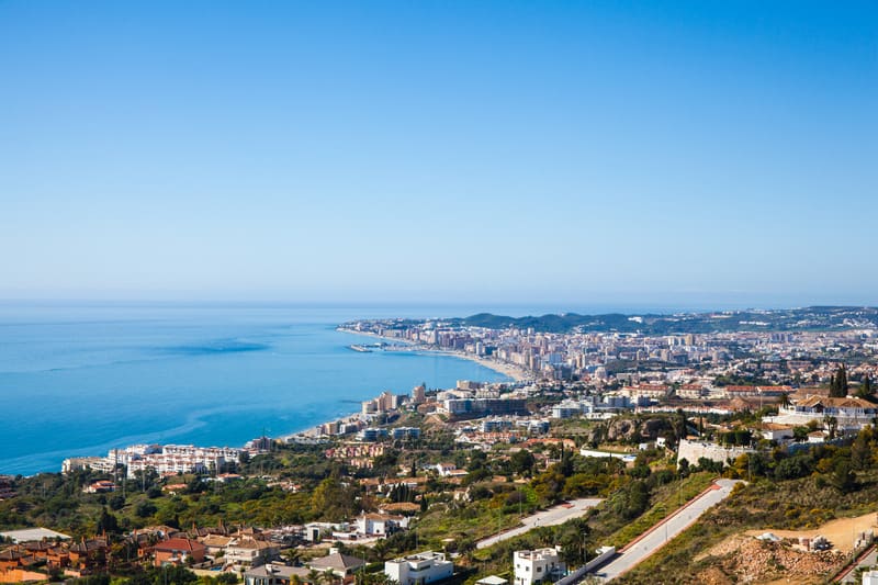 aerial view of Fuengirola filled with houses, trees, and the Spanish coast