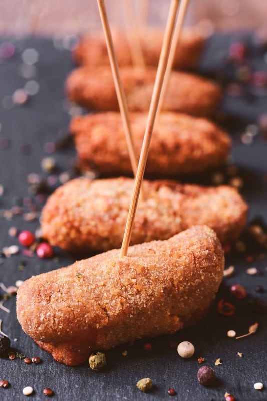 closeup of some spanish ham croquettes, served as tapas, on a slate surface