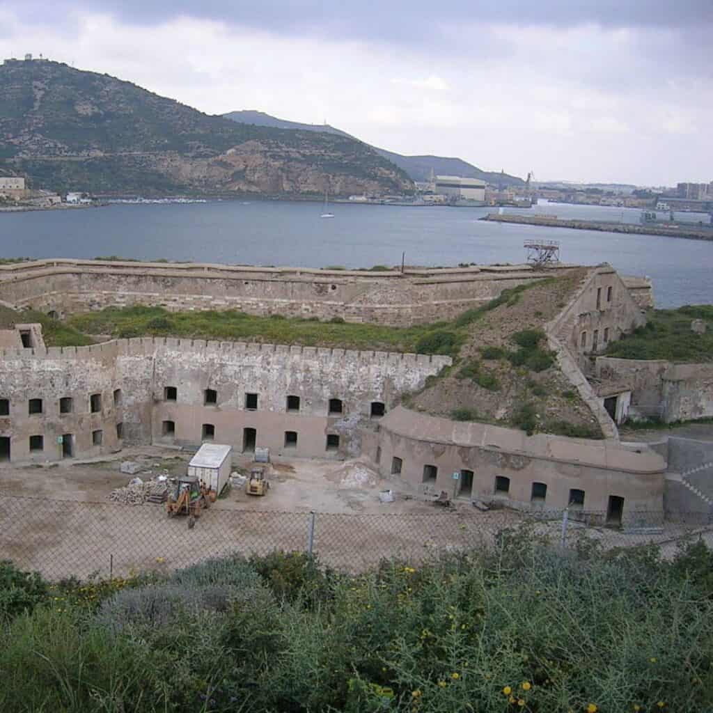 an old building near a body of water with a view of the city