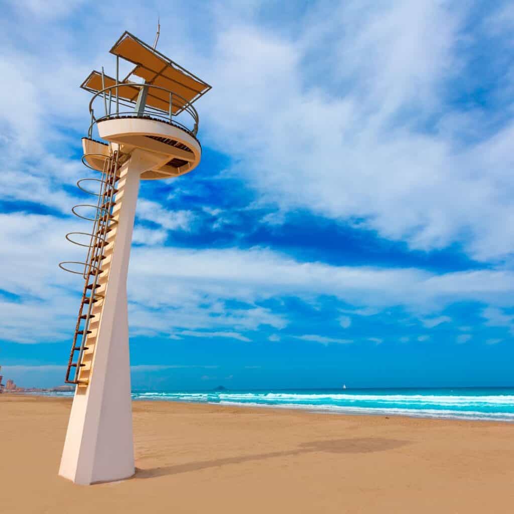 a lifeguard tower on the beach with a blue sky in the background