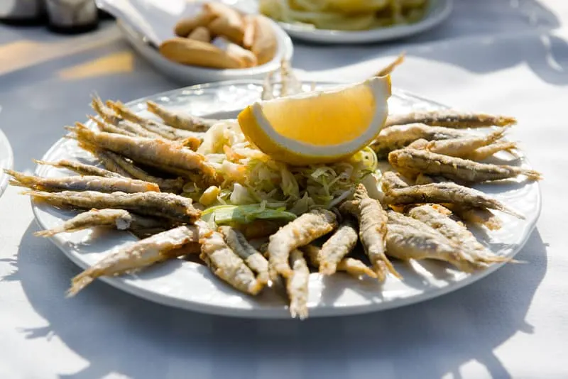 Plate of deep fried anchovies with lemon and salad. 25 Best Spanish Seafood Recipes to Try at Once!