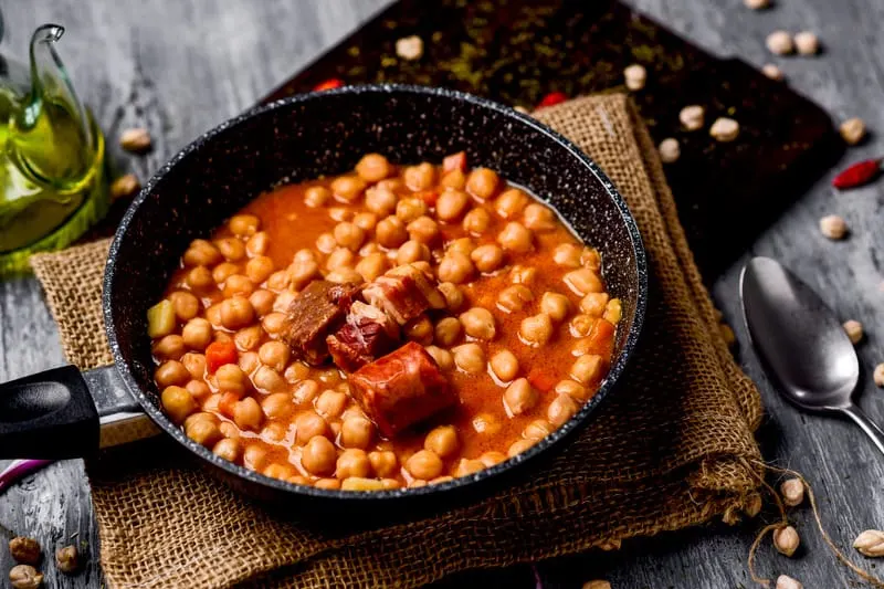 a black bowl containing Garbanzo Bean Soup With Ham