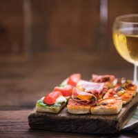 tapas and wine served on wooden board