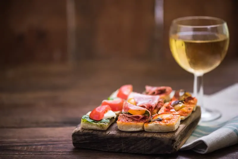 tapas and wine served on wooden board in Granada, Spain