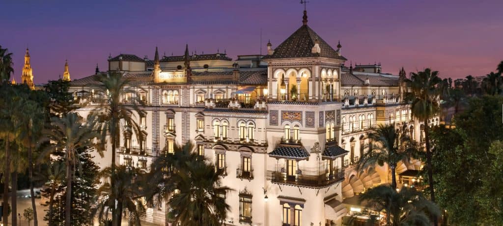 alfonso xiii hotel seville, a beautiful hotel surrounded by trees during sunset