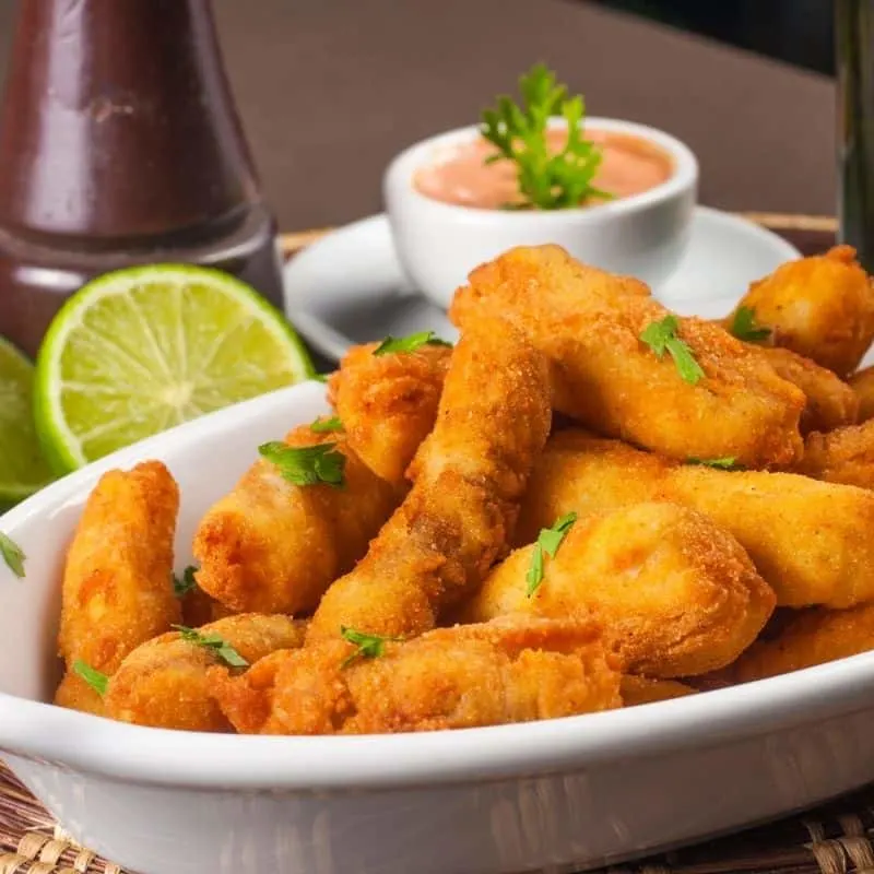 spanish mackerel cutlets in a bowl served with sauces. 