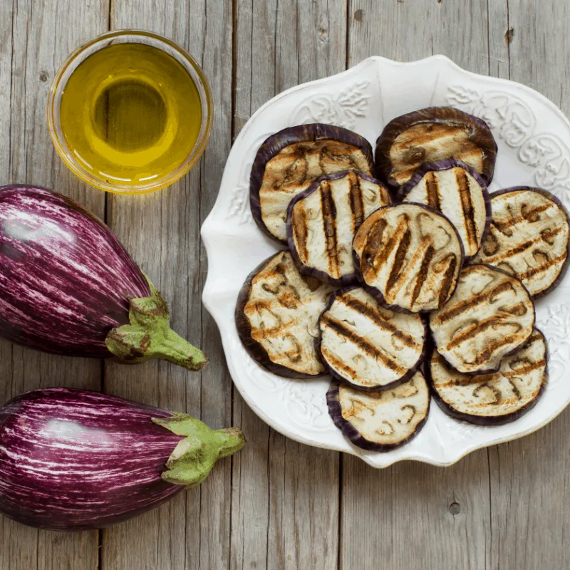 berenjenas fritas con miel, fried eggplants on a white plate with wooden background. 