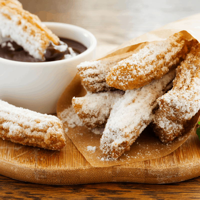 Homemade Churros on a wooden board with chocolate sauce