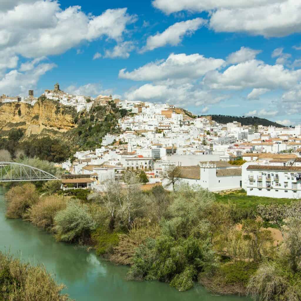 White houses of Arcos de la Frontera overlooking the greenish Guadalete River