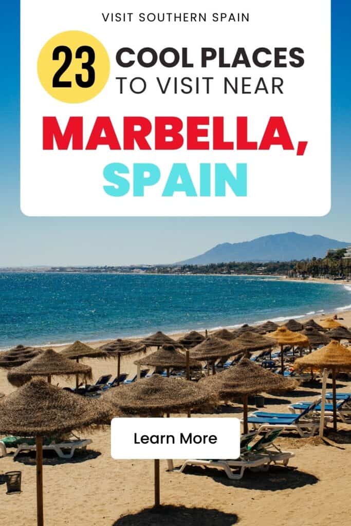 A beach in Marbella with blue water and calm water. There are a lot of blue lounge chairs with umbrellas.