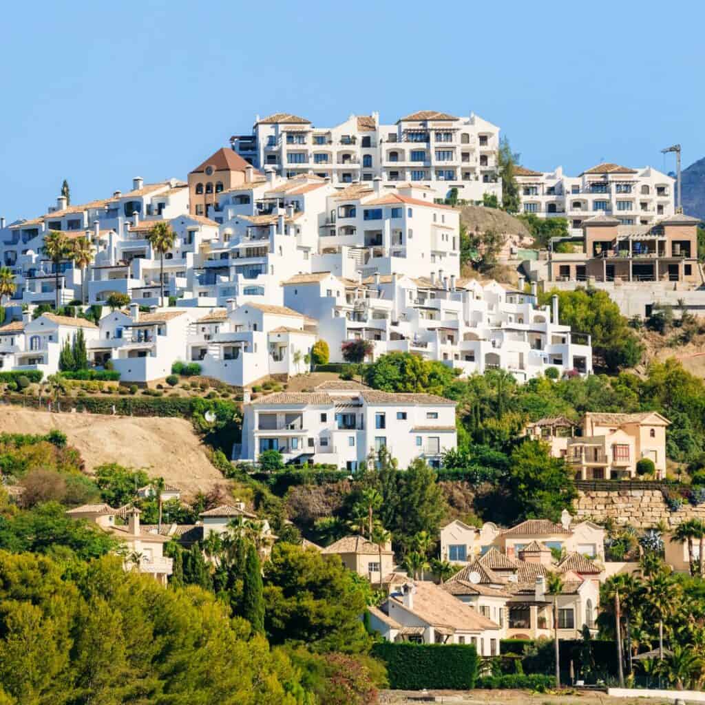 white houses on a hillside with trees below