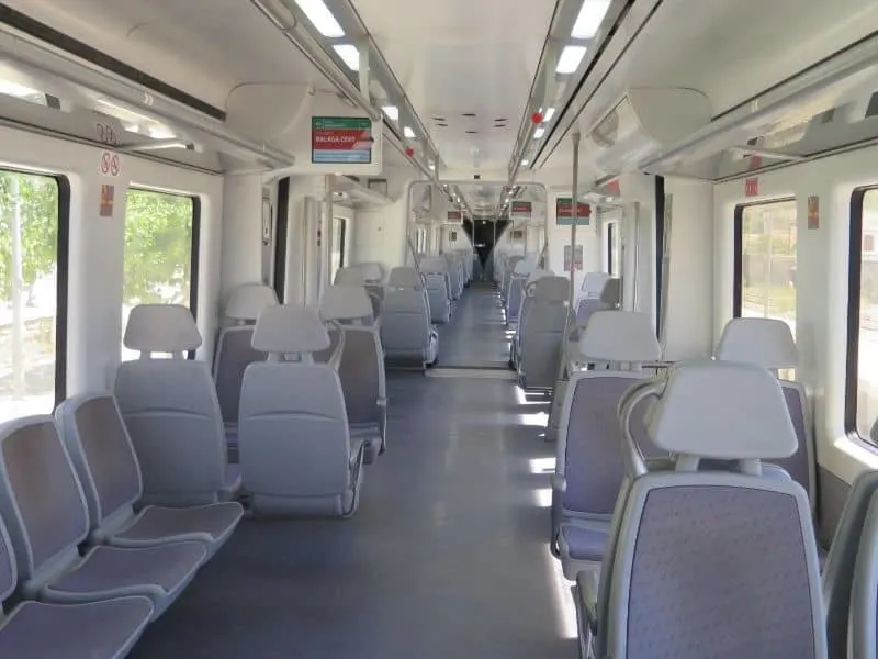 inside of a Spanish train filled with empty chairs