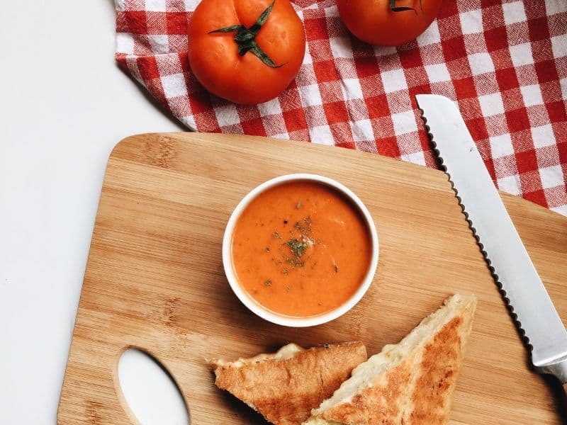 keto gazpacho served with grilled cheese sandwich on a wooden board. 