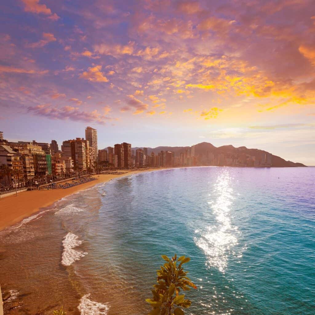 the beach and city filled with buildings during a sunset in Benidorm