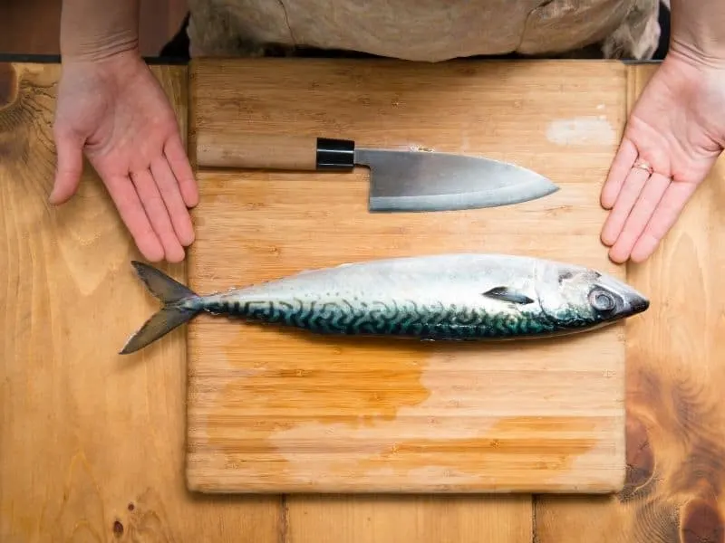 mackerel fish on a wooden plate ready to be cut.