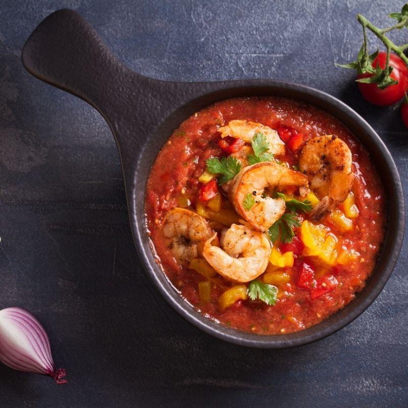 spicy Gazpacho with Shrimp in a pot on a kitchen table.