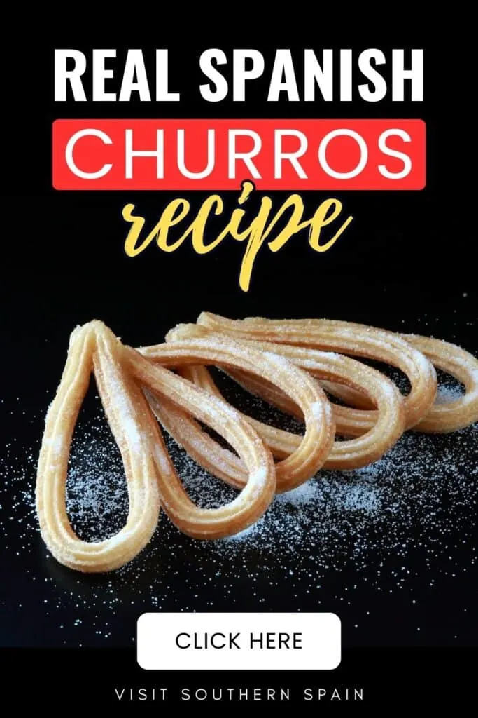 Churros are laid down on their sides on a black surface with its sugar on it.