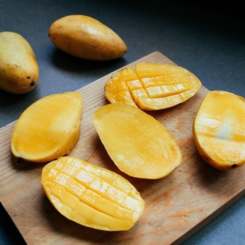 mango cut into pieces on a wooden  board for the gazpacho de mango