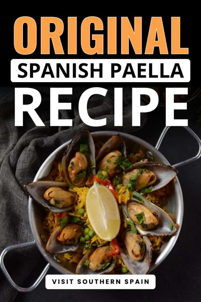 A stainless steall small deep pot is in between a gray cloth. Inside the pot has a paella. It is topped withh big mussels, herbs and a slice of lime in the middle.