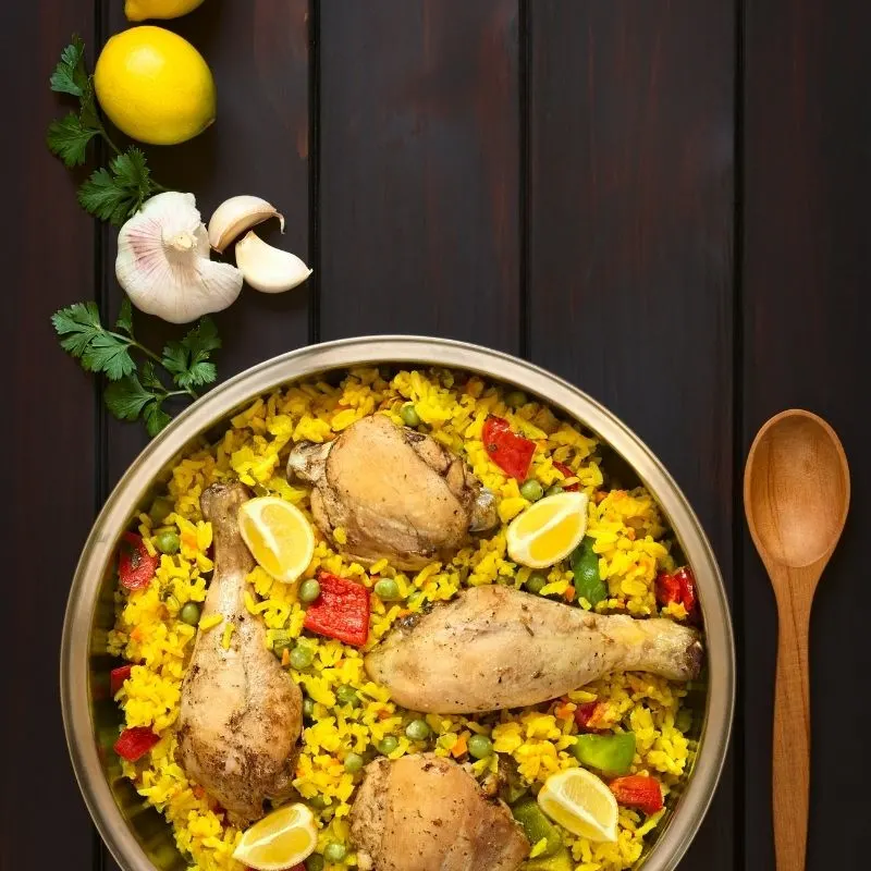 paella with chicken in a bowl on a black surface