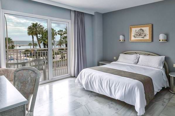 a bedroom in Soho las vegas with a window and a balcony with sea views