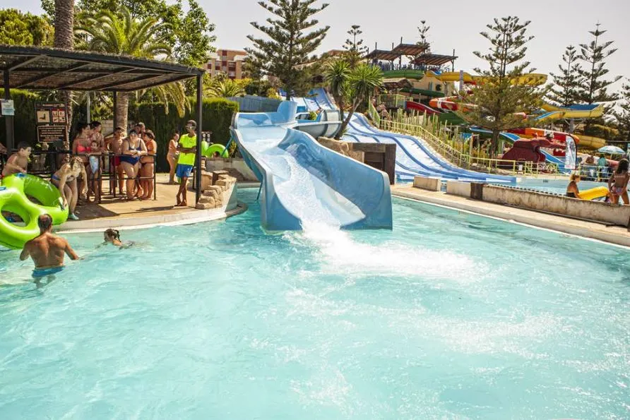 a pool and a slide with many people around