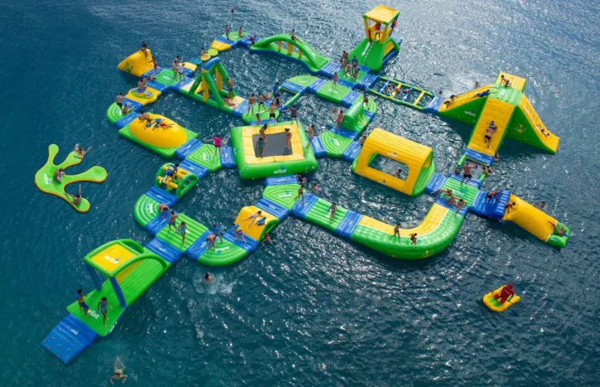 a waterpark in a body of water with many people enjoying