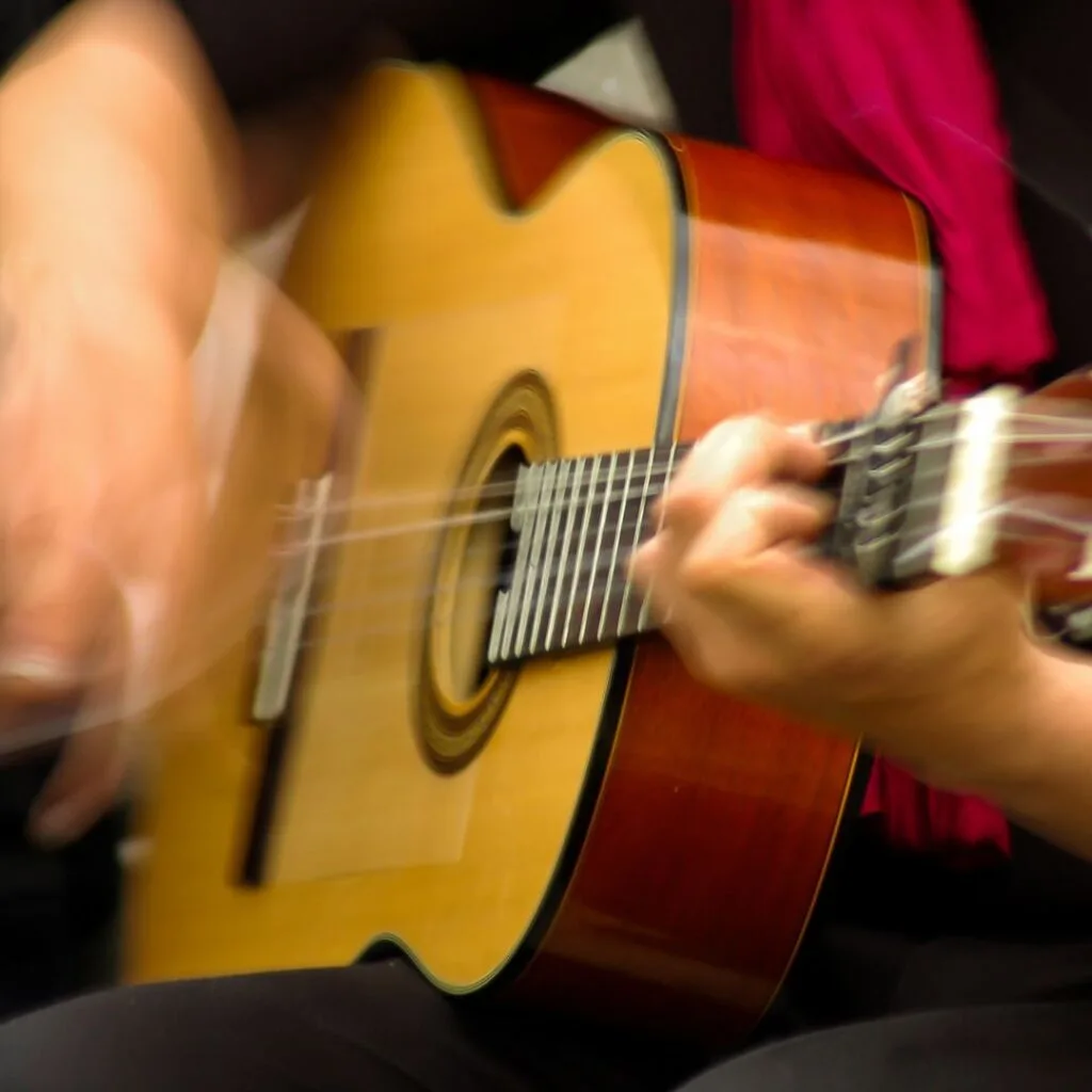 a closeup of an man with an acoustic guitar