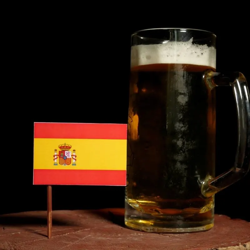 a glass of beer beside a toothpick side-Spanish Flag