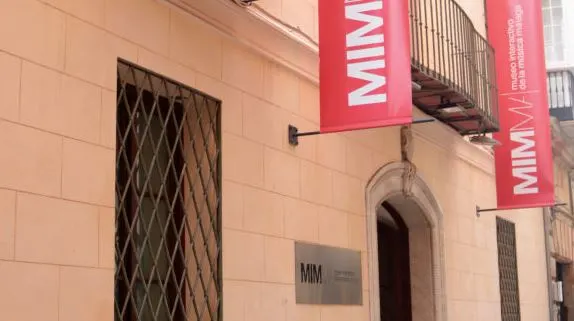 a brick brown building with a red banner with MIM