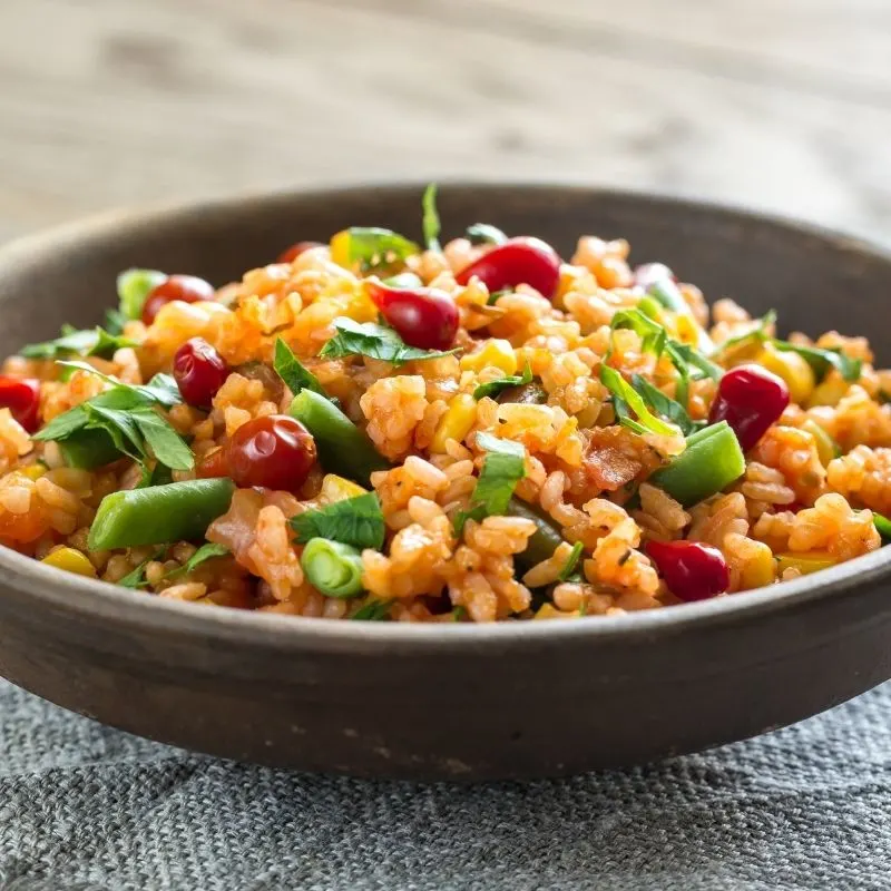 spanish rice with corn recipe in a wooden bowl