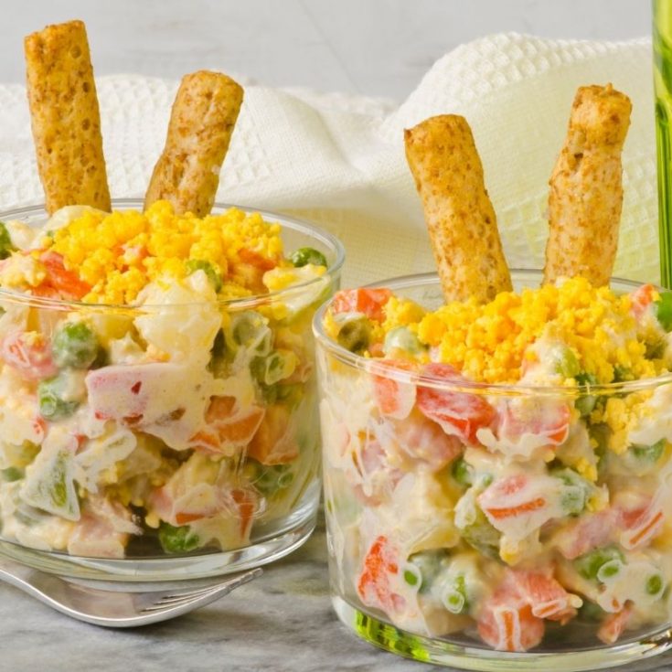 2 bowls of ensaladilla rusa served with some crackers.