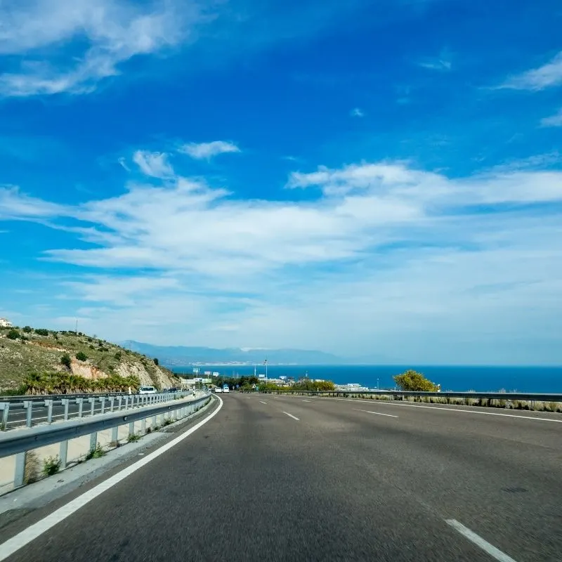 an empty road with a blue sky from a driver's view point