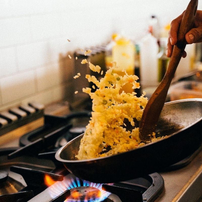 rice in a pan being cooked on the stove.