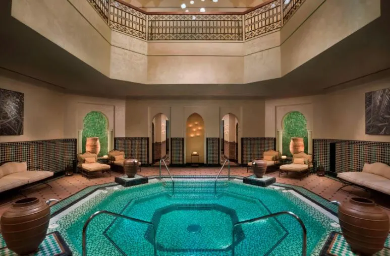 a circular room and pool inside the Heavenly Spa by Westin La Quinta with pool chairs and brown accents