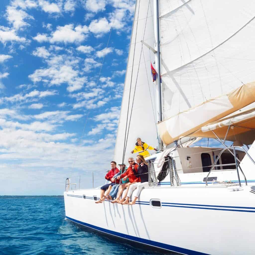 a group of people on a sailboat in the ocean