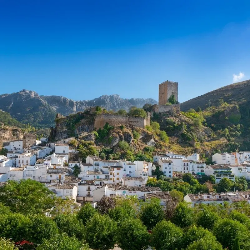 Cazorla a white town filled with white houses by the foot of the mountain with a castle perched atop and mountains at the back