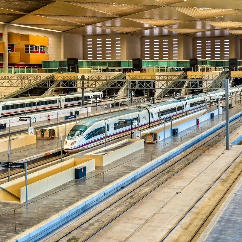 A train station with stopped trains waiting to go from Barcelona to Seville.
EXACTLY How to get from Barcelona to Seville
