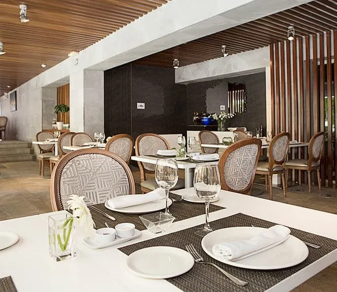 interior of the dining area at Hospes Palacio de los Patos with plates and utensils on the tables and chairs