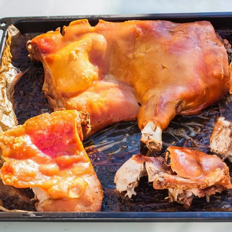 cooked Cochinillo chopped pieces on a tray