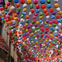 a street with lots of colorful paper lanterns hanging