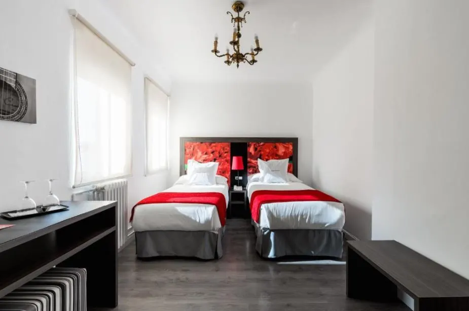 the bedroom of Hotel Sevilla with red and white sheets and black undertones